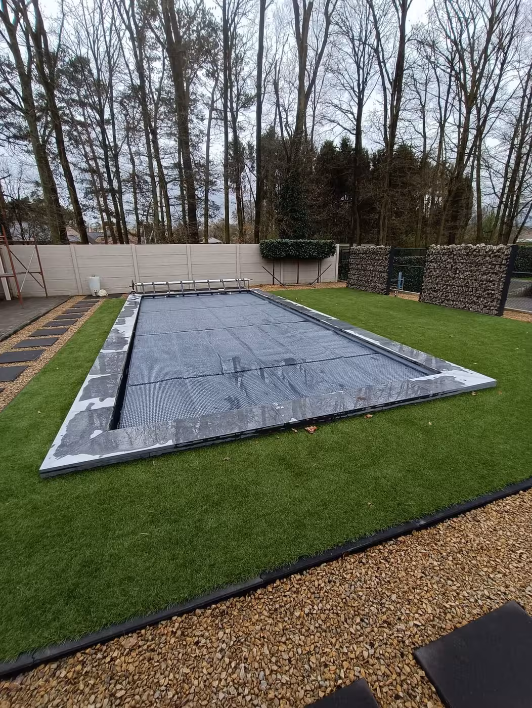 Zwembadafdekking geplaatst in de afgewerkte tuin