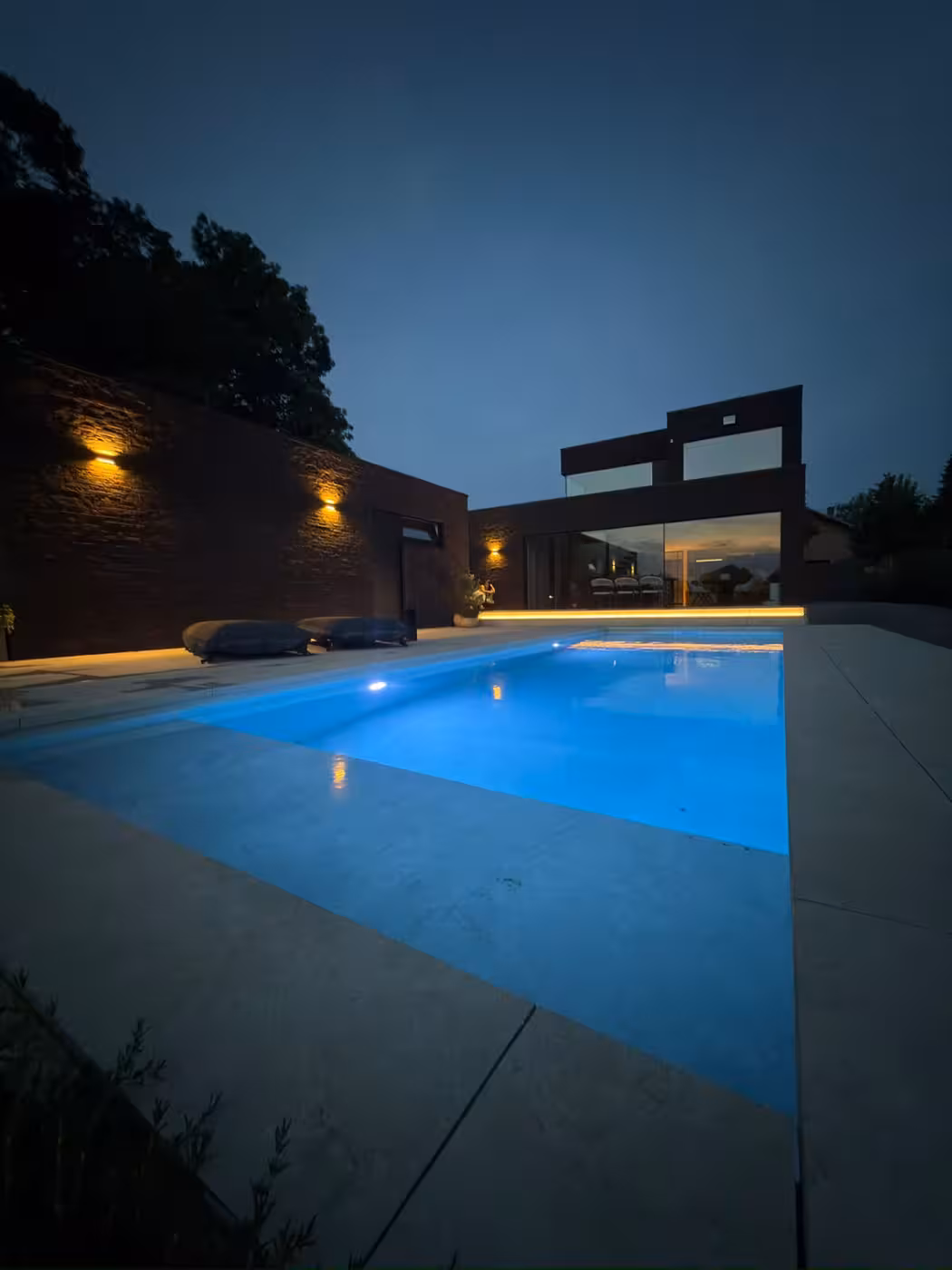 Verlicht zwembad met lichtgrijze polyester bekleding